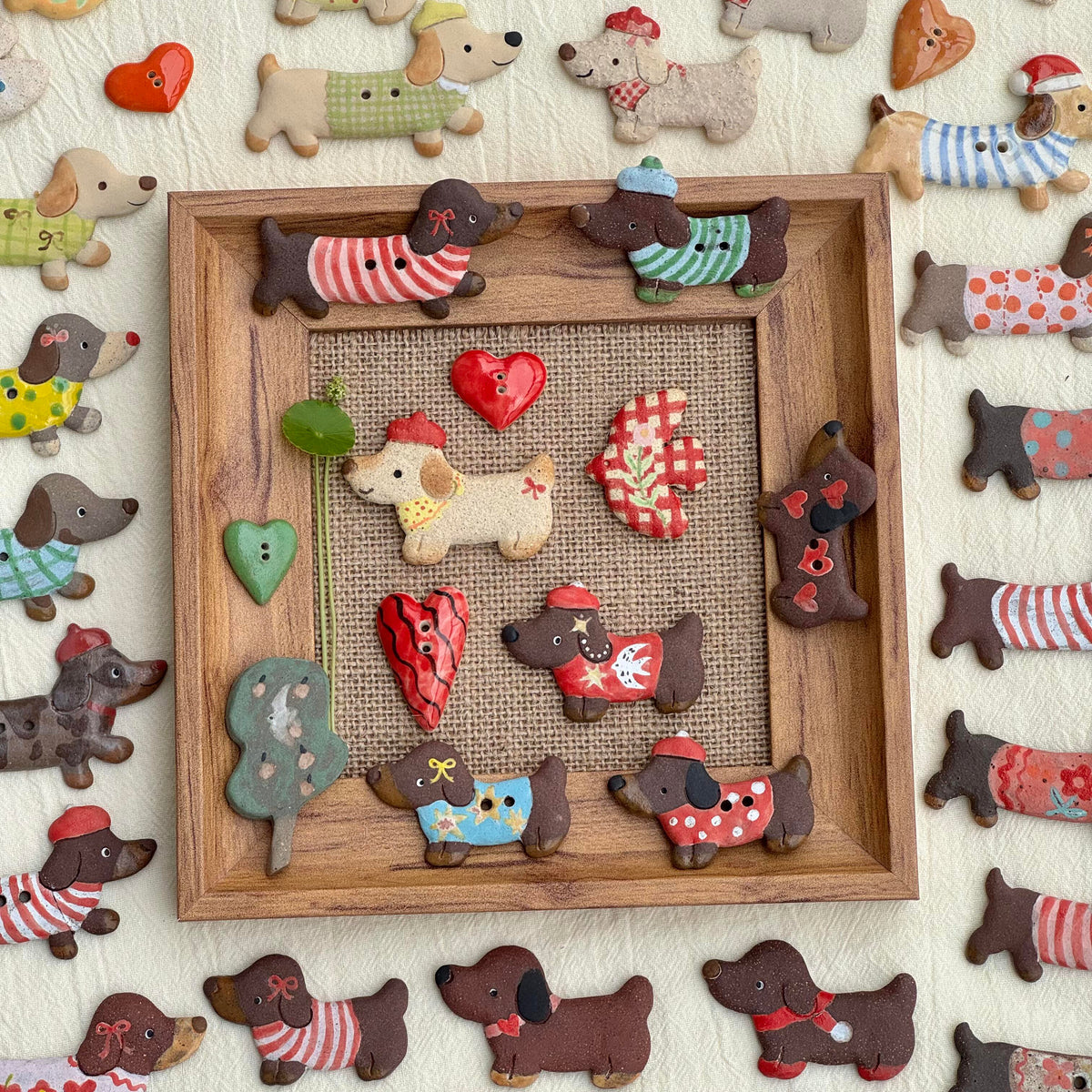 Assorted handmade ceramic dachshund fridge magnets displayed with other small ceramic decorations