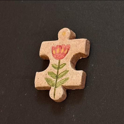 Hand-painted clay puzzle magnet with a white tulip-shaped flower on a golden yellow background