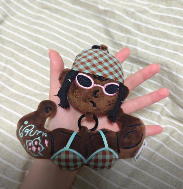 Close up of a cute aesthetic plush bag accessory resting on a hand