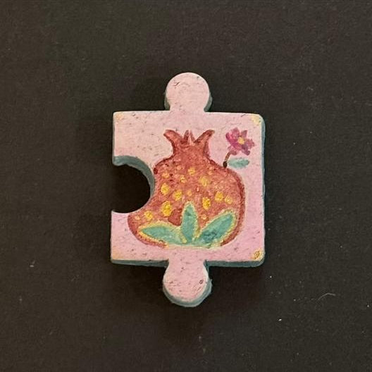 Hand-painted clay puzzle magnet featuring a red patterned flower with green leaves on a light pink background