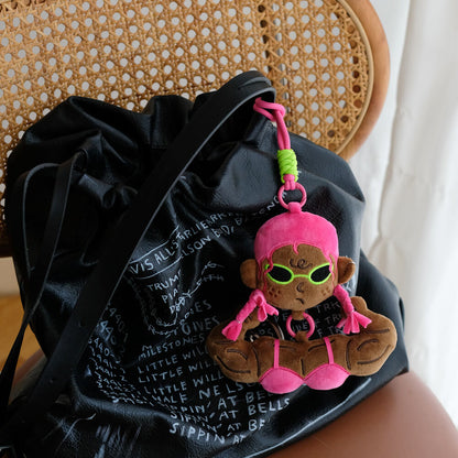 Pink bikini funny muscle girl plush keychain accessorizing a black bag