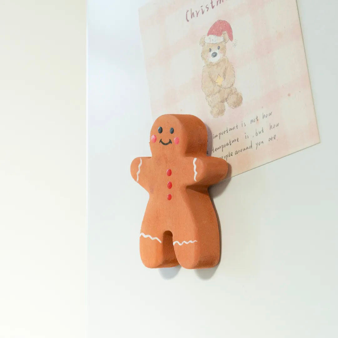 Hand-carved wooden gingerbread man magnet shown at an angle with its three-dimensional shape