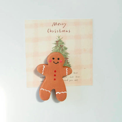 Hand-carved wooden gingerbread man fridge magnet with smiling face and painted icing details