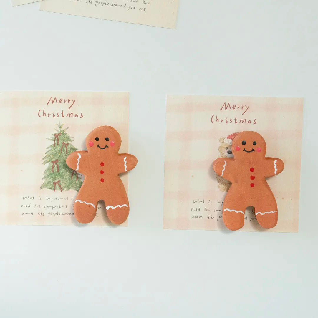 Two handmade wooden gingerbread man magnets displayed side by side with Christmas cards