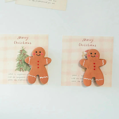 Two handmade wooden gingerbread man magnets displayed side by side with Christmas cards