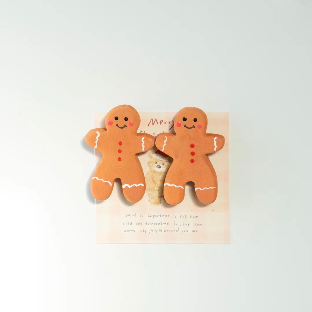 Two hand-painted wooden gingerbread man fridge magnets displayed together
