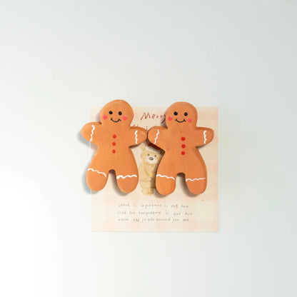 Two hand-painted wooden gingerbread man fridge magnets displayed together