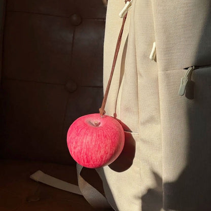 Lifelike handmade foam apple charm hanging from a backpack.