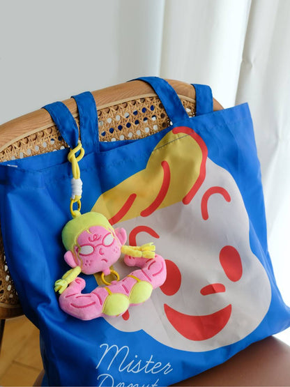 Yellow hair cute aesthetic plush bag accessory hanging on a blue canvas tote bag