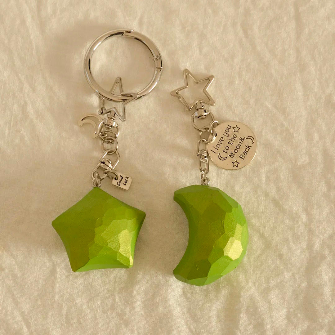 Matching green wooden star and crescent moon keychains shown side by side